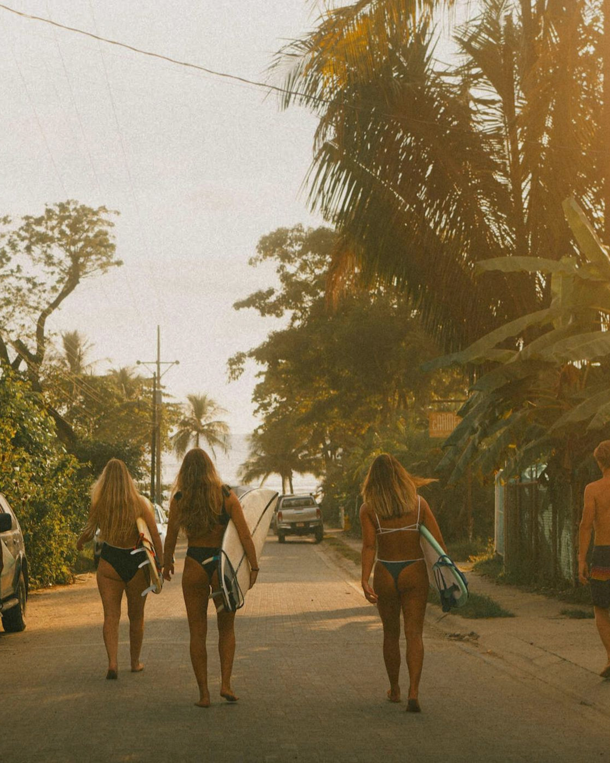 Surfers walking toward a Costa Rica beach at sunset